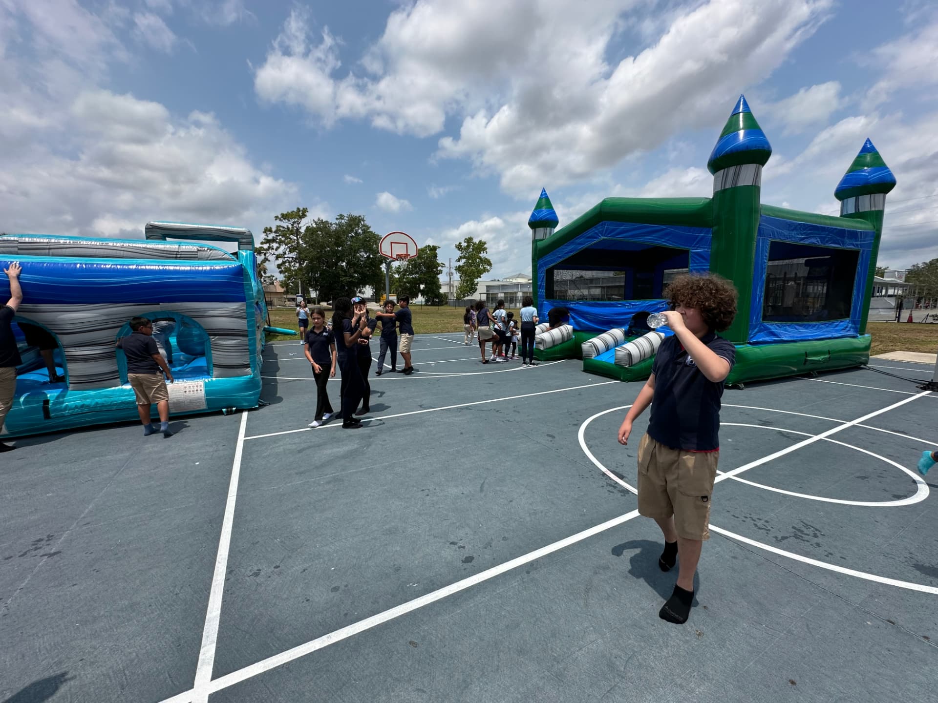 Bounce house and obstacle course set up on a school basketball court