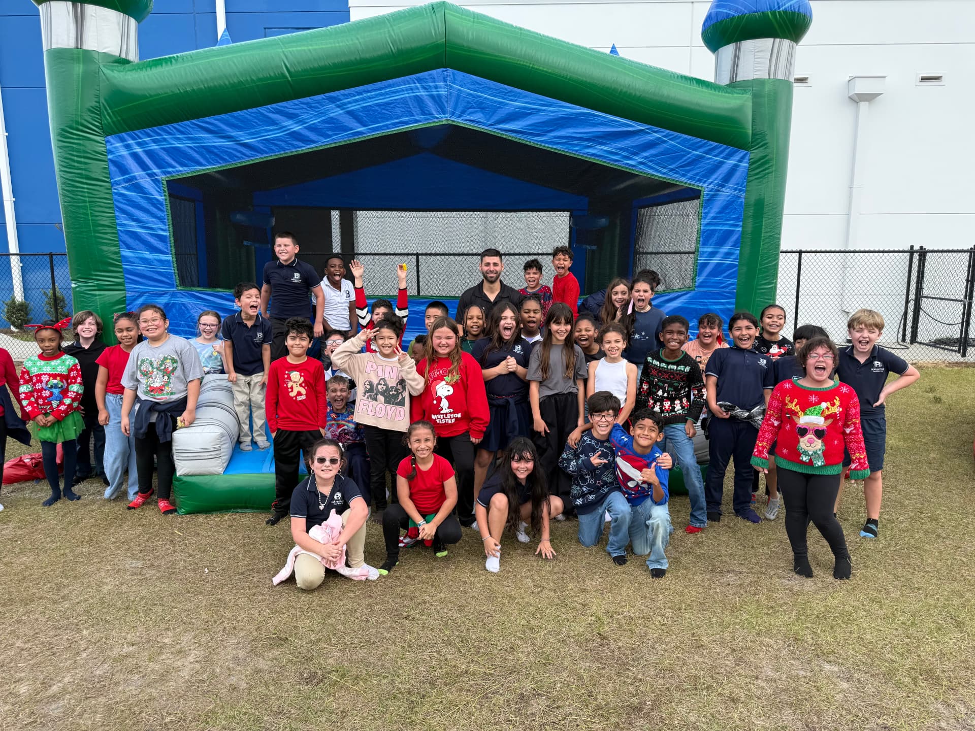 A full class posing in front of a Bounce Hype bounce house