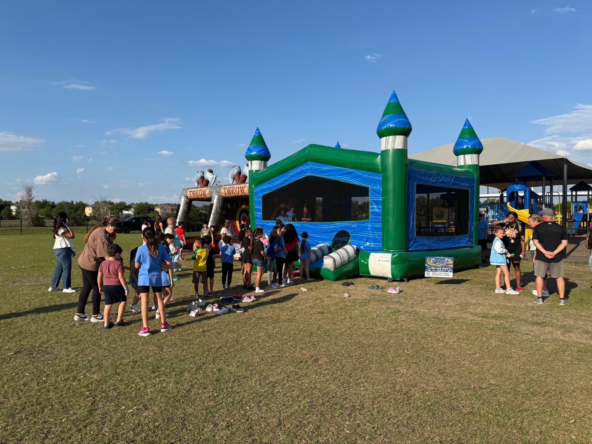 Students lined up for a bounce house and throw game at a school event